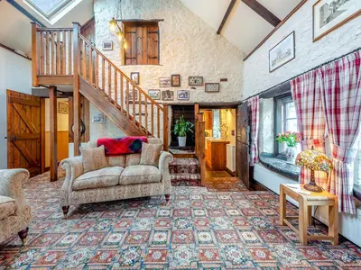 a living room with a couch and a staircase at Yr Hen Efail in Abergorlech