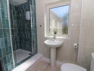 a bathroom with a sink and a shower and a toilet at Towyn Hall in New Quay