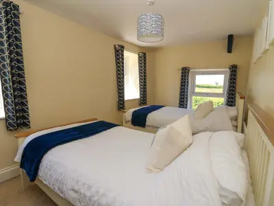 a bedroom with two beds and a window at Towyn Hall in New Quay