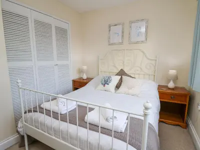 a bedroom with a white bed with two night stands at Towyn Hall in New Quay