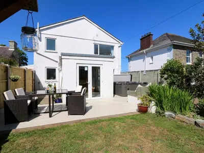 a patio with a table and chairs in front of a house at Towyn Hall in New Quay