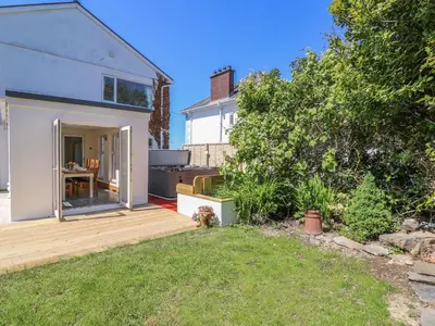 a backyard with a wooden deck and a house at Towyn Hall in New Quay