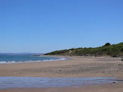 a sandy beach with the ocean in the background at Towyn Hall in New Quay