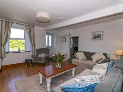 a living room with a couch and a table at Towyn Hall in New Quay