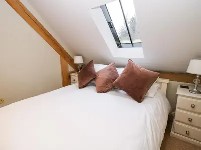 a bedroom with a white bed with pillows at Pultheley Cottage in Montgomery
