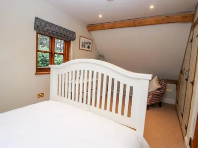 a white crib in a childs bedroom with a window at Pultheley Cottage in Montgomery