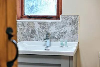 a white sink in a bathroom with a window at Finest Retreats - The Onibury in Onibury