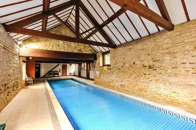 a large swimming pool in a building with a brick wall at Finest Retreats - The Park in Onibury