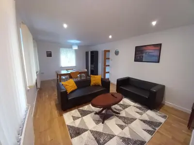 a living room with a couch and a table at Penglais Lodge in Aberystwyth