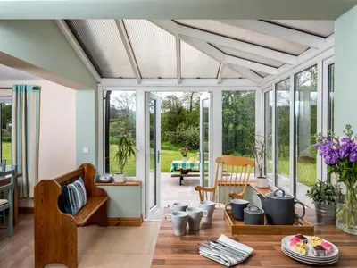 a living room with a table and chairs and windows at 4 Bed in Brecon oc-bn151 in Devynock