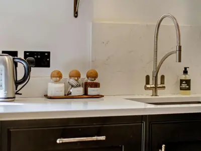 a kitchen counter with three figurines on a tray next to a sink at 2 Bed in Hereford oc-82095 in Byford