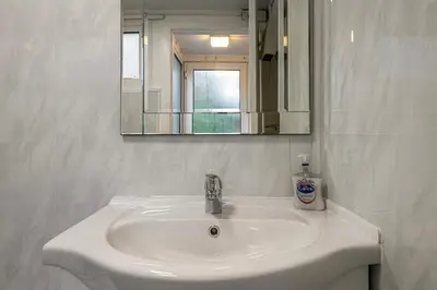 a white sink in a bathroom with a mirror at Cheerful 2 bedroom cottage with garden in Llanelltyd