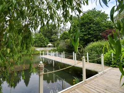 a wooden bridge over a pond in a garden at 4 Bed in Newtown oc-86784 in Bettws Cedewain