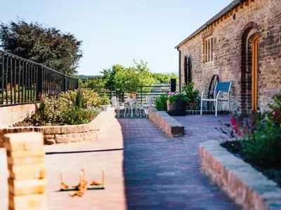 a brick patio with tables and chairs and a building at 4 Bed in Church Stretton oc-87695 in Cardington