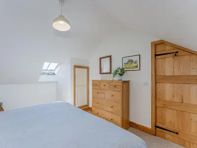 a bedroom with a bed and a wooden dresser at 4 Bed in Church Stretton oc-87695 in Cardington