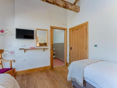 a bedroom with a bed and a tv on the wall at 4 Bed in Church Stretton oc-87695 in Cardington