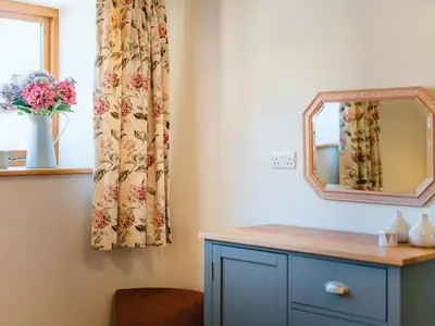 a room with a mirror and a dresser and a window at 4 Bed in Church Stretton oc-87695 in Cardington