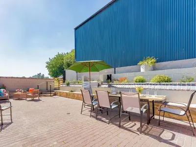 a patio with a table and chairs and a green umbrella at 4 Bed in Church Stretton oc-87695 in Cardington