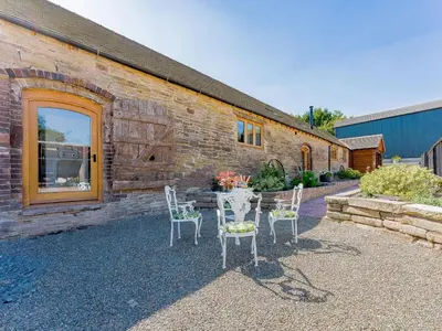a table and chairs in front of a brick building at 4 Bed in Church Stretton oc-87695 in Cardington