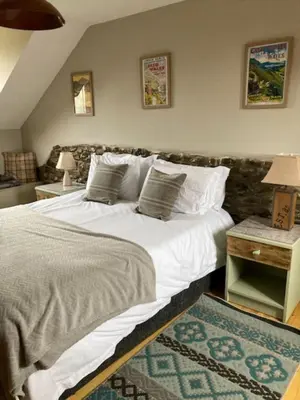 a bedroom with a large bed with white sheets and pillows at Mwsogl - Luxurious Family Fishing Lodge Near Aberaeron With Private Fishing in Cross Inn