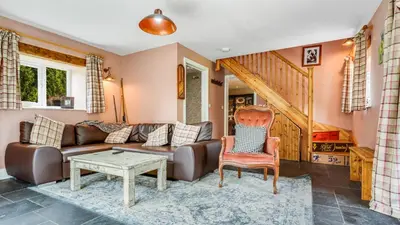 a living room with a couch and a table at Mwsogl - Luxurious Family Fishing Lodge Near Aberaeron With Private Fishing in Cross Inn