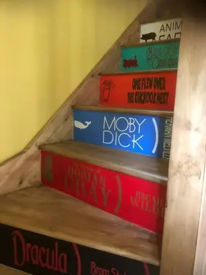 a stack of books on a wooden staircase at Rhedyn - Cosy Fishing Lodge Near Aberaeron in Cross Inn