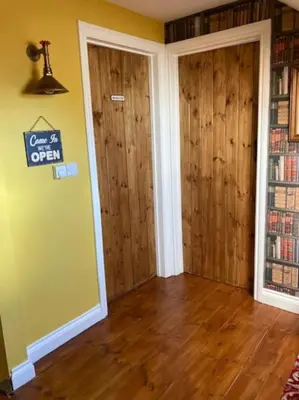 an empty room with wooden floors and two doors at Rhedyn - Cosy Fishing Lodge Near Aberaeron in Cross Inn