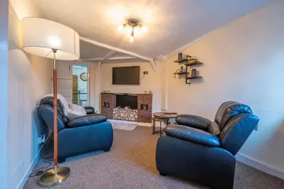 a living room with two blue chairs and a lamp at Town Centre Cottage 3 Bedroom inc Parking (1 car) in Shrewsbury