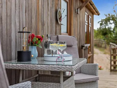 a table with glasses and flowers on a patio at 2 Bed in Leominster oc-78637 in Stoke Prior