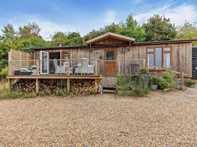 a wooden house with a deck and chairs on it at 2 Bed in Leominster oc-78637 in Stoke Prior