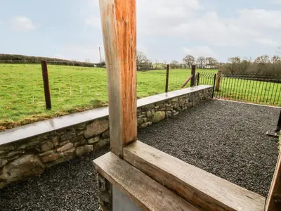 a view of a field through a wooden window at Ty Gwyn in Welshpool