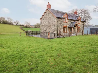 an old stone house in the middle of a field at Ty Gwyn in Welshpool