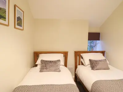 two beds in a room with white walls at Bwthyn Y Bugail in Blaenau-Ffestiniog