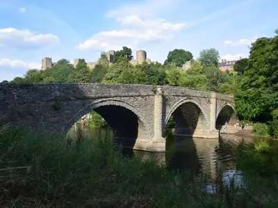 a stone bridge over a river with buildings in the background at 1 Bed in Presteigne oc-55285 in Presteigne