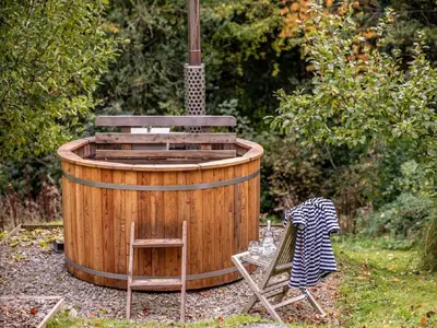 a wooden hot tub with a wooden chair and a wooden chair at 2 Bed in Brecon oc-59734 in Talgarth