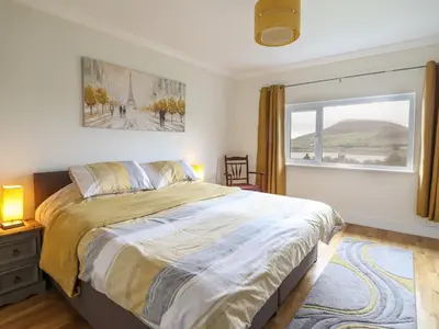 a bedroom with a large bed and a window at Craig Yr Ronwy in Bala
