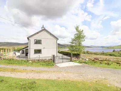 a small white house on the side of a road at Craig Yr Ronwy in Bala