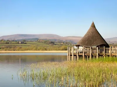 a hut with a thatched roof on a lake at 1 Bed in Brecon oc-bn270 in Llansantffread