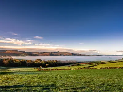 a foggy field with a lake in the distance at 1 Bed in Brecon oc-bn270 in Llansantffread