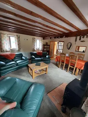 a living room with couches and a table at The Barn at the Mill in Selattyn