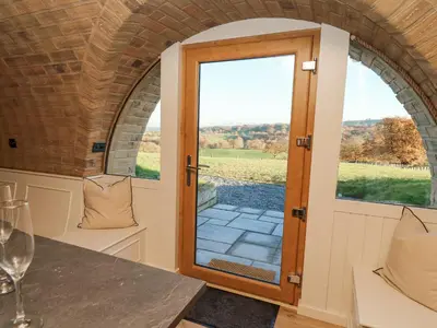 a room with a door and a table with wine glasses at Tan y Wawr- Onnen in Welshpool