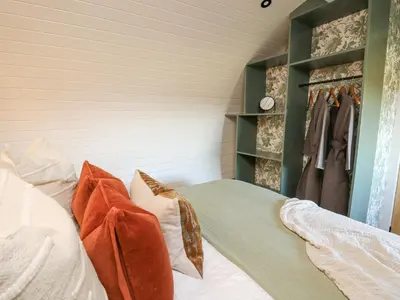 a bedroom with a bed with pillows and a closet at Tan y Wawr- Onnen in Welshpool