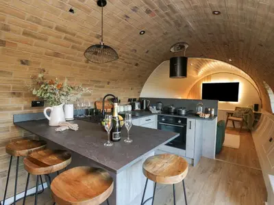 a kitchen with a counter and stools in a room at Tan y Wawr- Onnen in Welshpool