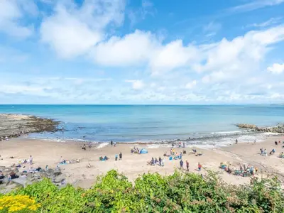a group of people on a beach near the ocean at Y Stabl in New Quay