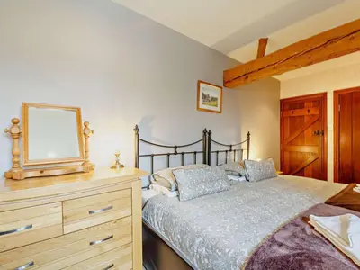 a bedroom with a bed and a dresser with a mirror at 2 Bed in Dyffryn Ardudwy oc-89438 in Dyffryn
