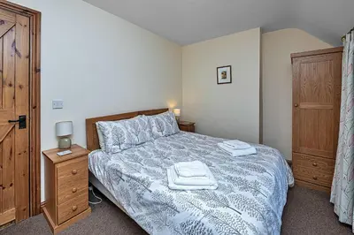 a bedroom with a bed with two towels on it at Finest Retreats - Llechwedd Mawr in Talybont