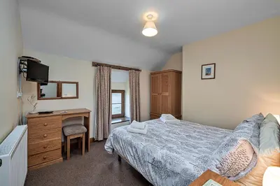a bedroom with a bed and a desk and a television at Finest Retreats - Llechwedd Mawr in Talybont