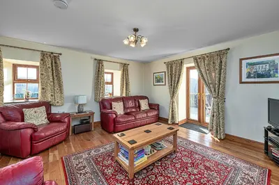 a living room with two red chairs and a coffee table at Finest Retreats - Helygen in Talybont