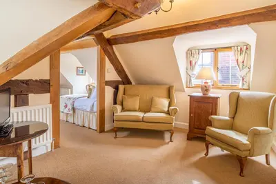 a attic room with two chairs and a bed at The Town House Ludlow in Ludlow