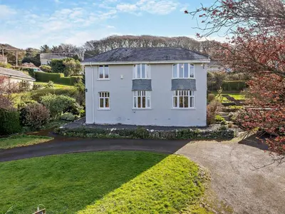an image of a white house with a yard at 4 Bed in Friog 42772 in Fairbourne